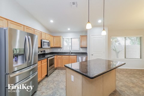 a large kitchen with stainless steel appliances and granite counter tops
