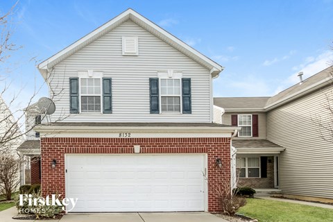 A two-story house with a garage is for sale.
