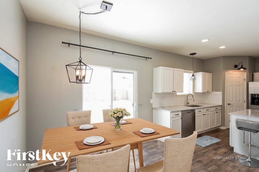 A dining room with a wooden table set for four.