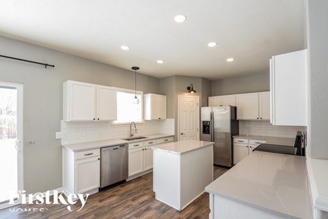 A modern kitchen with white cabinets and appliances.