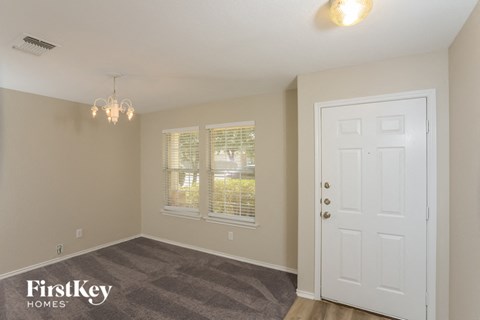 the living room of a house with a white door and window