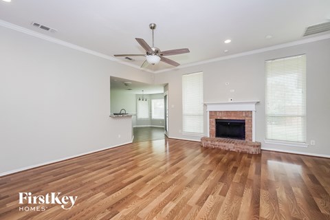 a living room with a fireplace and a ceiling fan