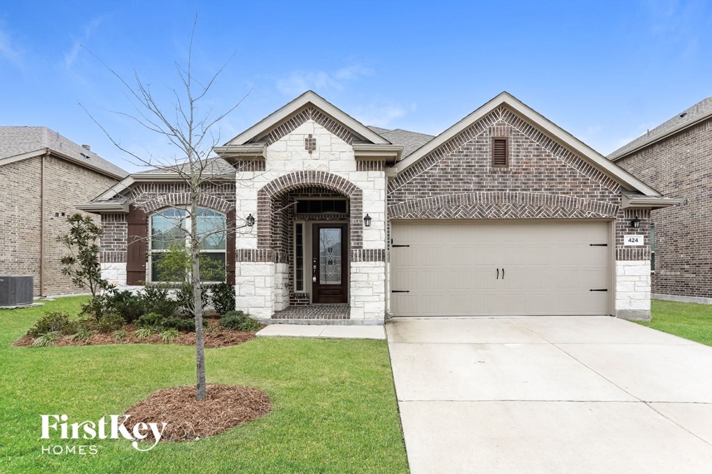 new home with brick and stone exterior and a garage