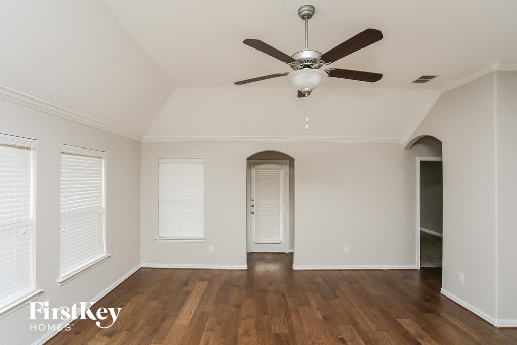 a living room with wood floors and a ceiling fan