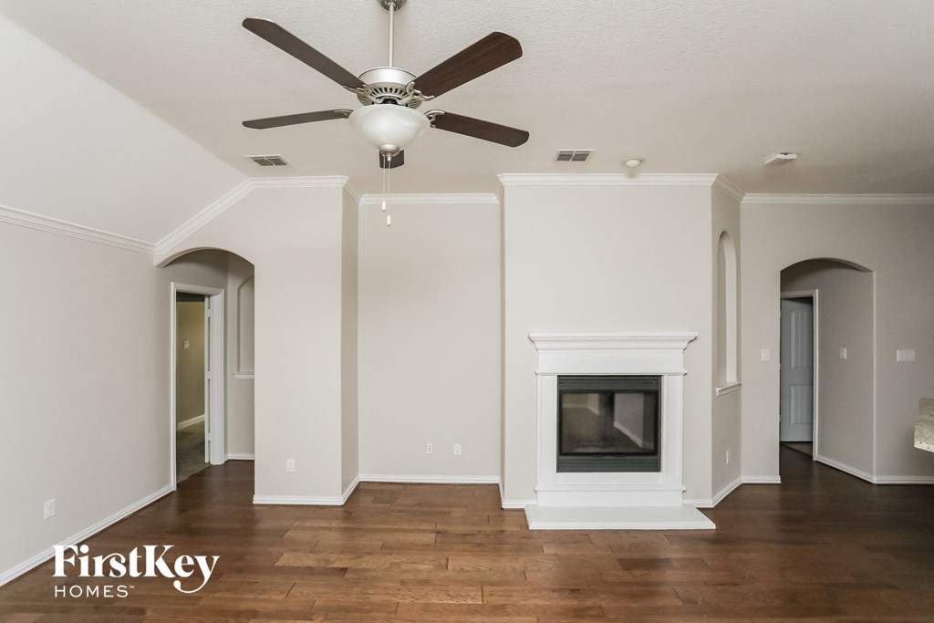 a living room with a fireplace and a ceiling fan