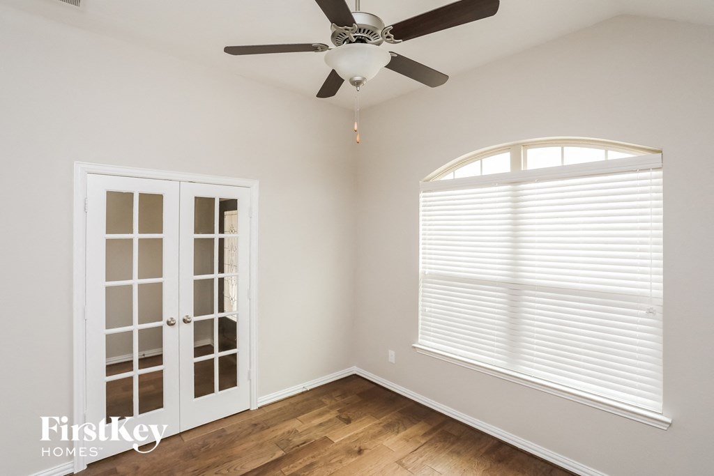 a bedroom with a ceiling fan and a window