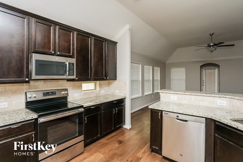 a kitchen with wooden cabinets and stainless steel appliances and granite counter tops