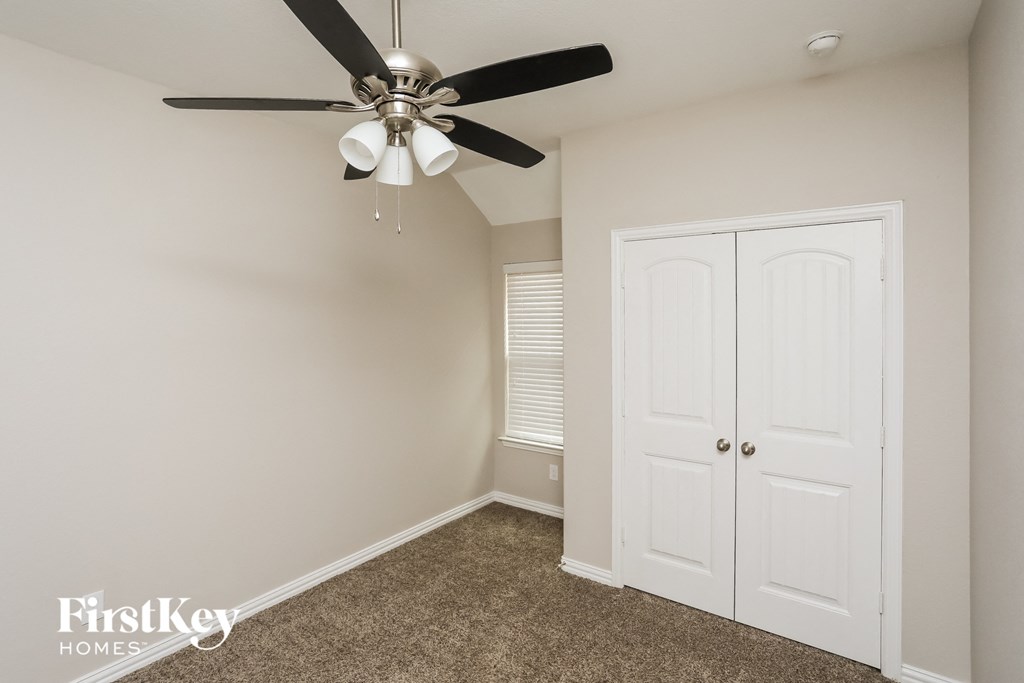 a bedroom with a ceiling fan and a closet