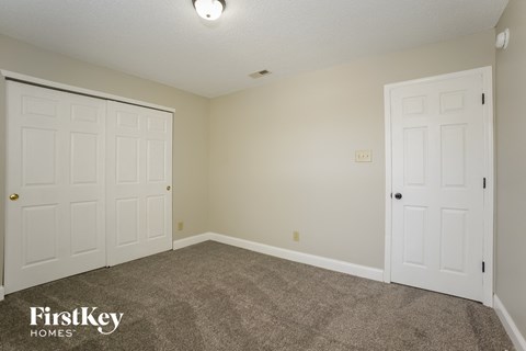 a bedroom with two white doors and a carpeted floor