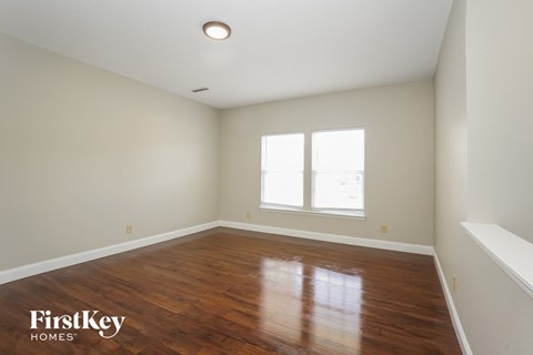 the living room with hardwood floors and a large window