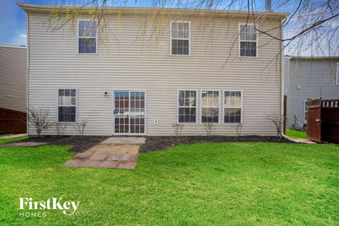 a side view of a white house with a yard and grass