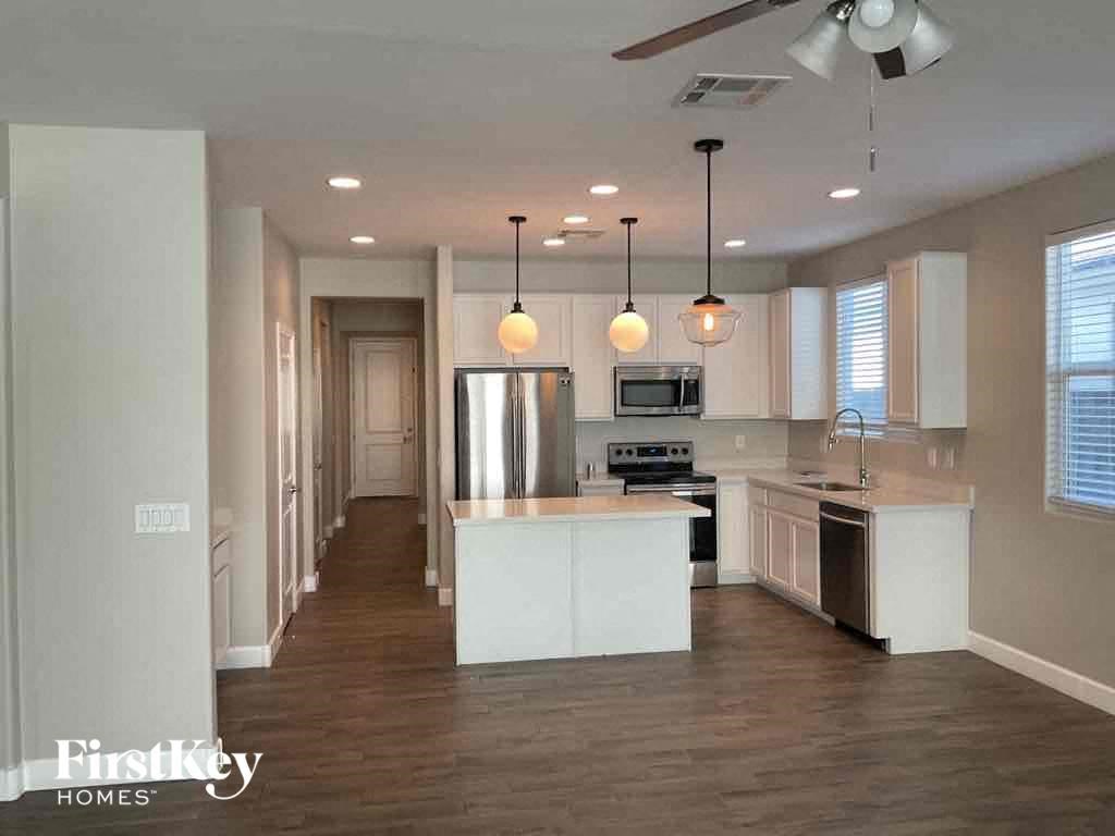A spacious kitchen with a center island and pendant lights.