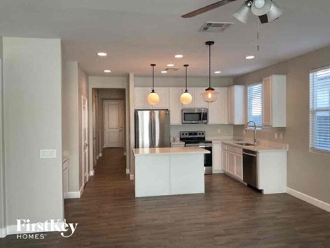 A spacious kitchen with a center island and pendant lights.