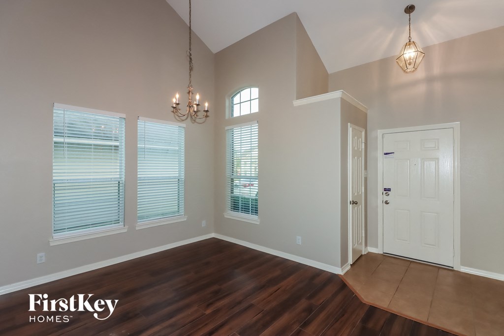 the living room of a home with a large window and a door