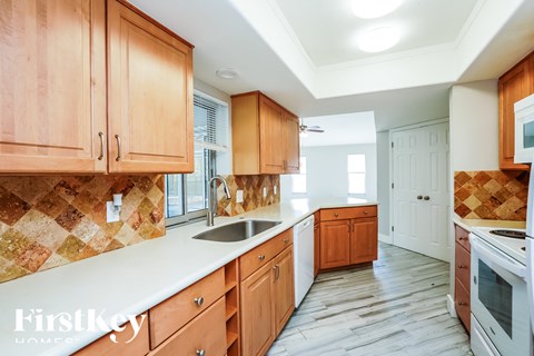 A kitchen with wooden cabinets and a checkered backsplash.