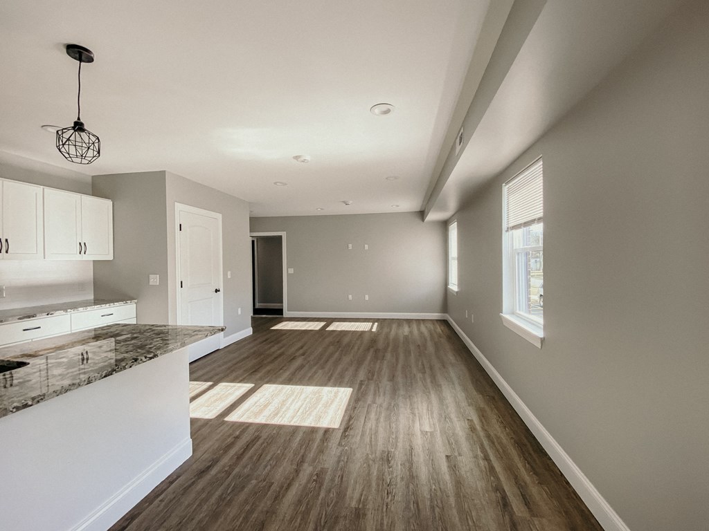 the view from the living room into the kitchen and dining room