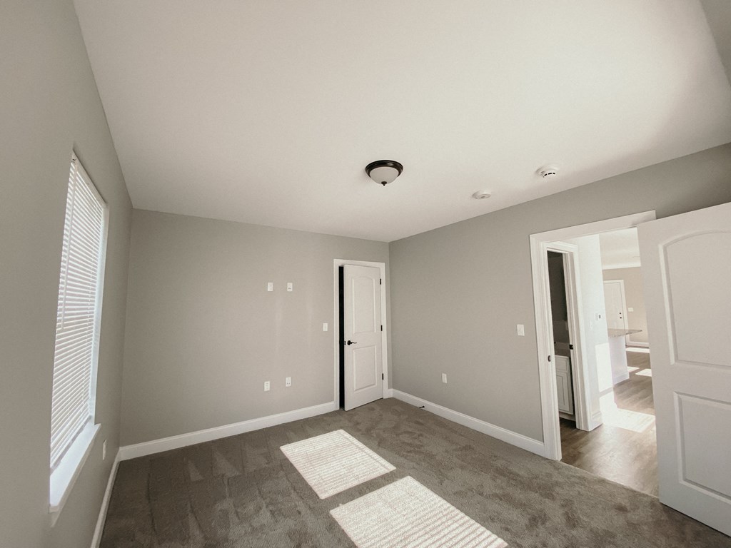 a empty living room with gray walls and a carpet