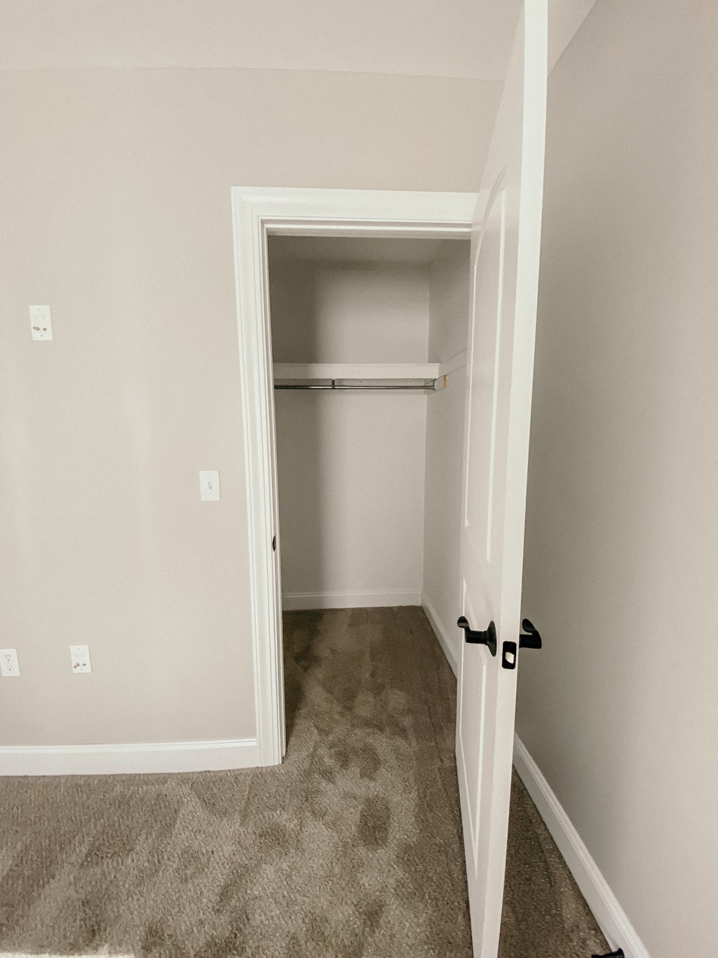 an empty closet in a home with a door open