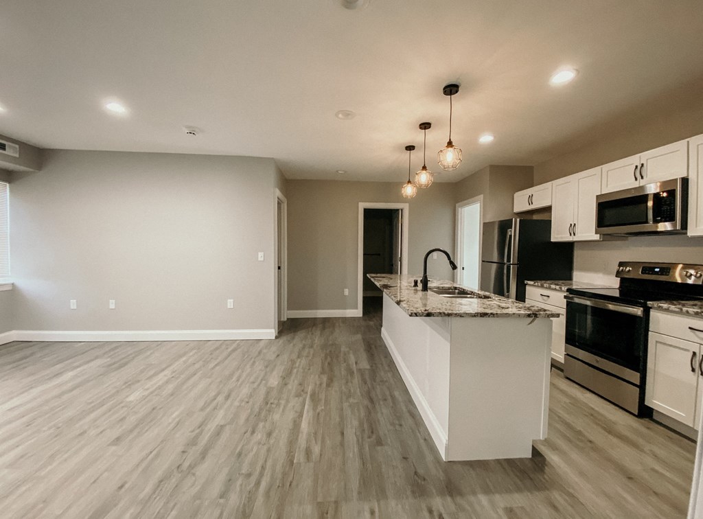 an empty kitchen with a marble counter top