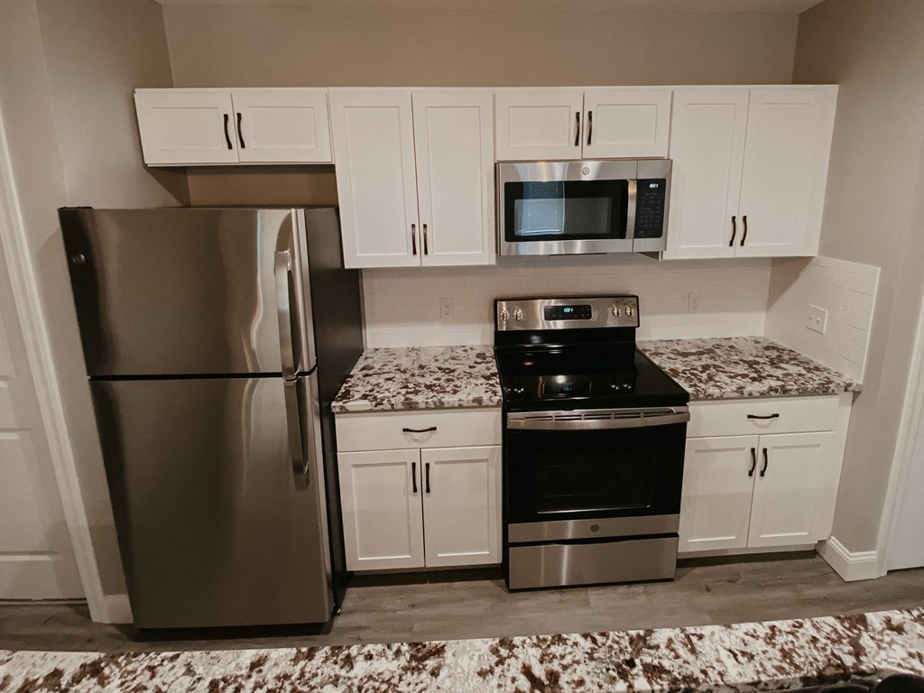 a kitchen with stainless steel appliances and white cabinets