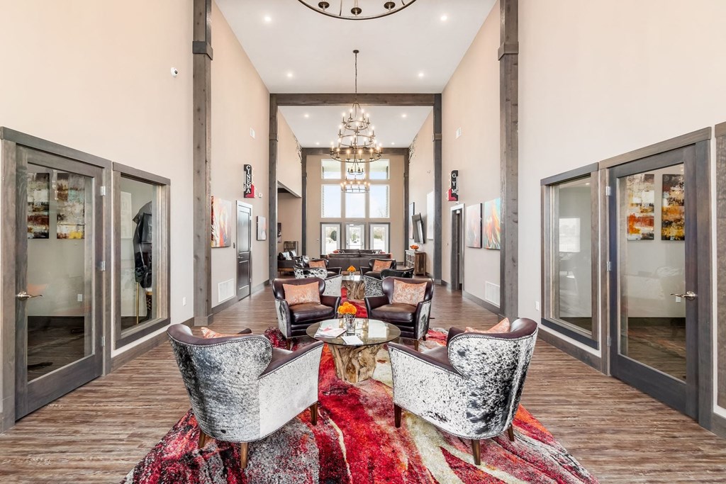 a lobby with chairs and a table and a chandelier