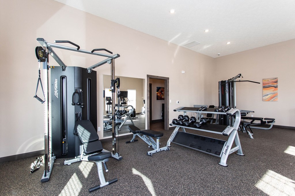 a gym with exercise equipment and weights on the floor