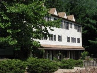 a white house with a porch and some trees
