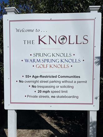 a sign for spring knolls on the side of a road