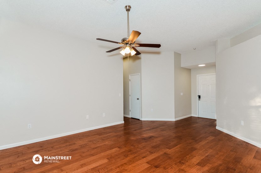 a living room with wood flooring and a ceiling fan