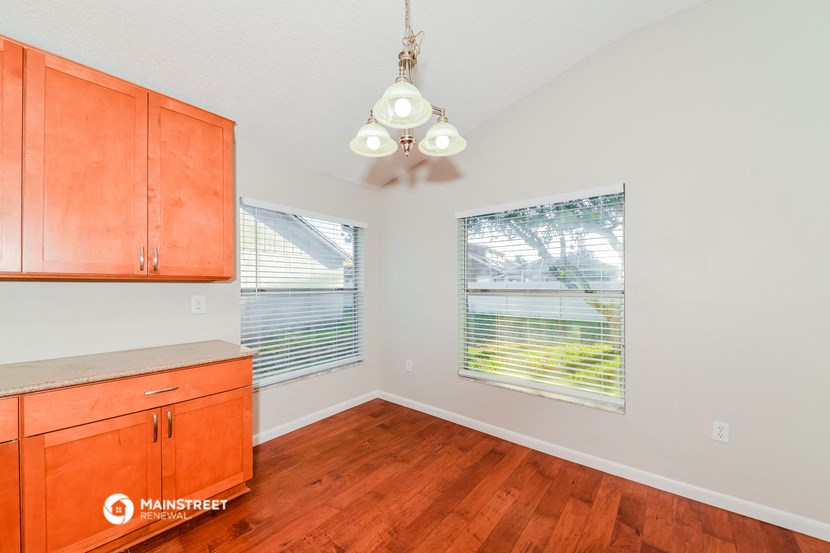 a kitchen with wood flooring and a ceiling fan
