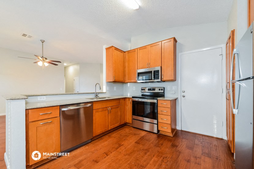 a kitchen with wooden cabinets and stainless steel appliances