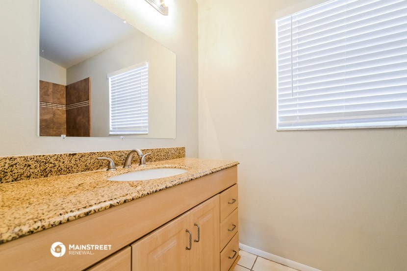 the bathroom has a large vanity with a sink and a mirror