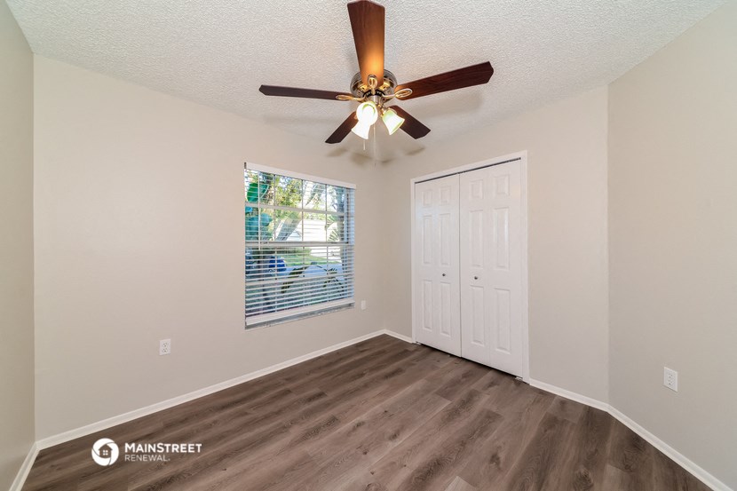 the living room of our two bedroom apartment atrium with ceiling fan and window