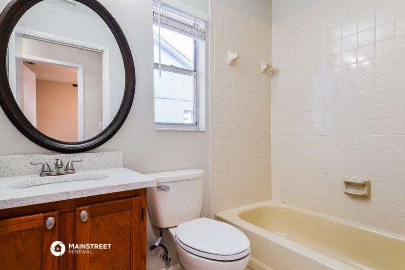 a bathroom with a toilet sink and tub and a mirror