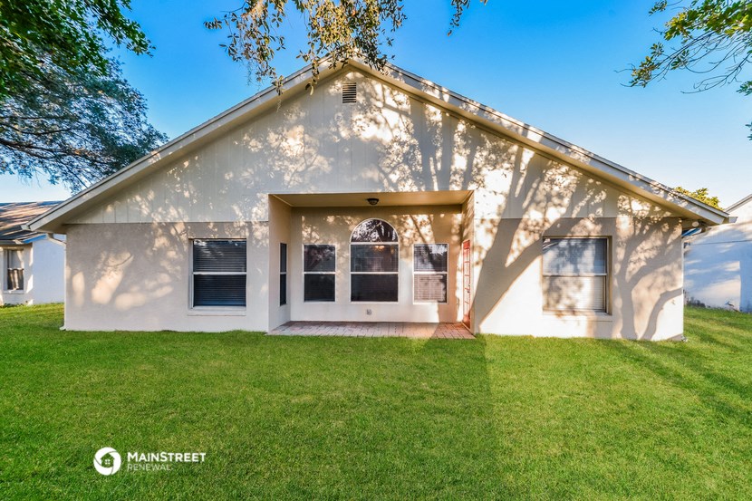 a white house with a lawn and a tree