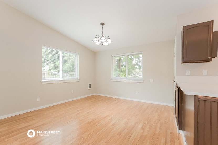 the living room and dining room of a home with wood flooring