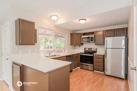 a kitchen with stainless steel appliances and white counter tops