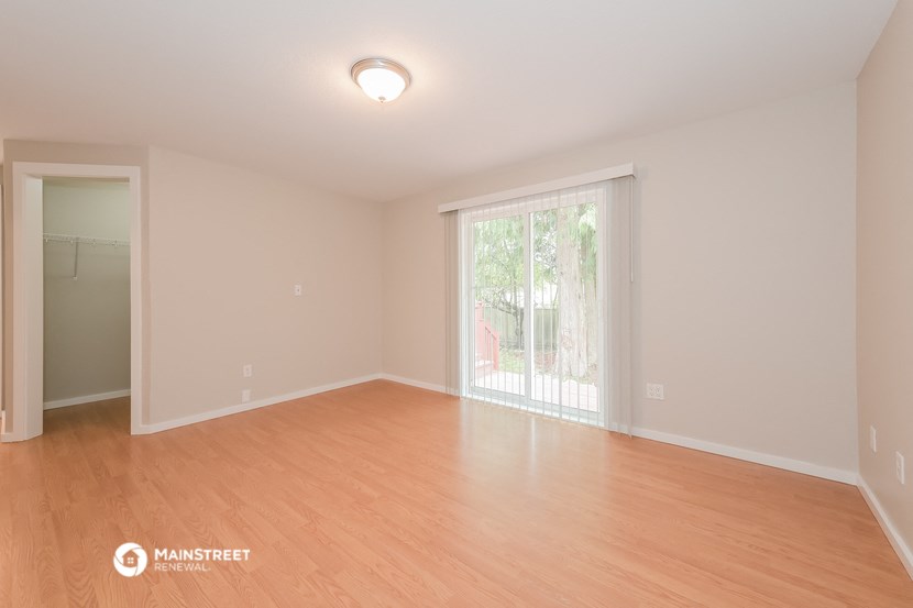 an empty living room with wood flooring and a sliding glass door