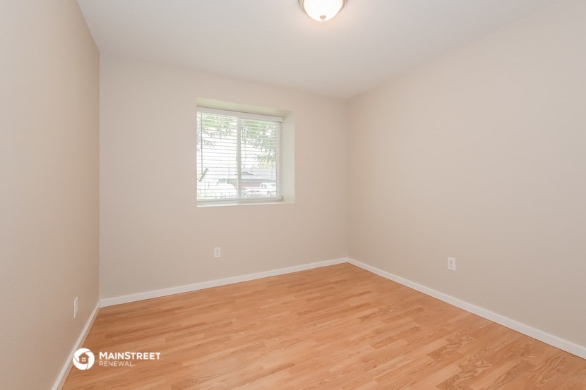 an empty room with a wooden floor and a window