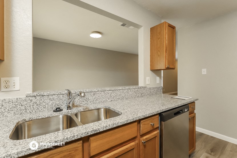 the kitchen has granite counter tops and stainless steel appliances