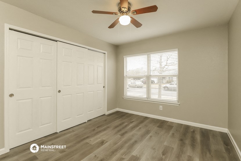 the bedroom has a large closet and a ceiling fan