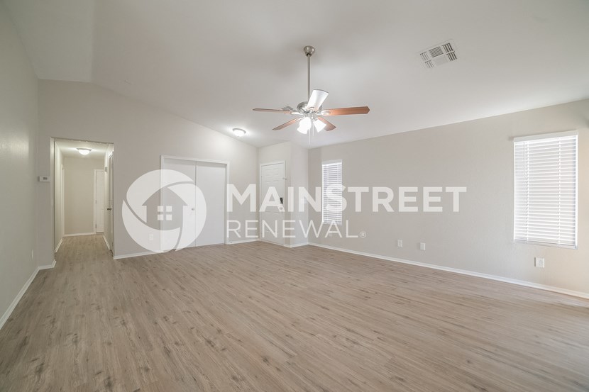 a large living room with a hard wood floor and a ceiling fan