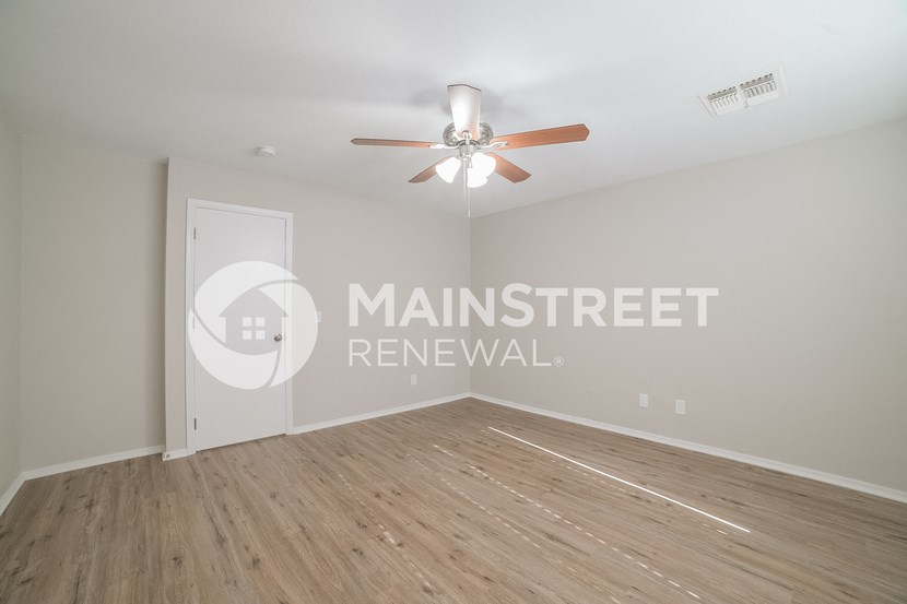 a room with a hard wood floor and a ceiling fan