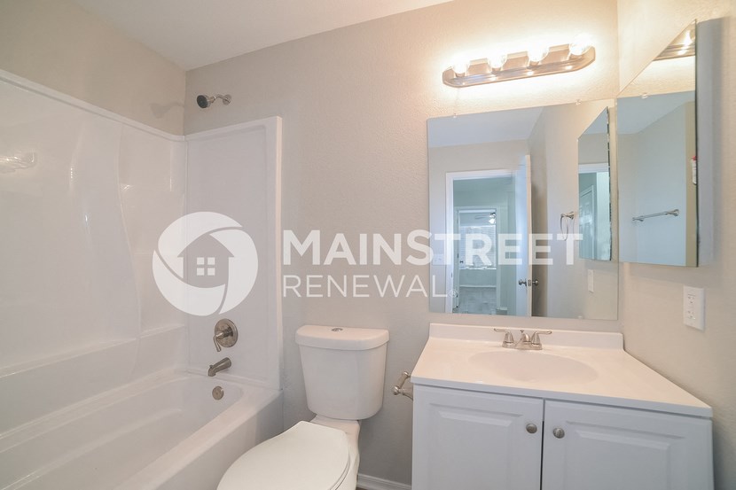 a renovated bathroom with a sink toilet and bath tub