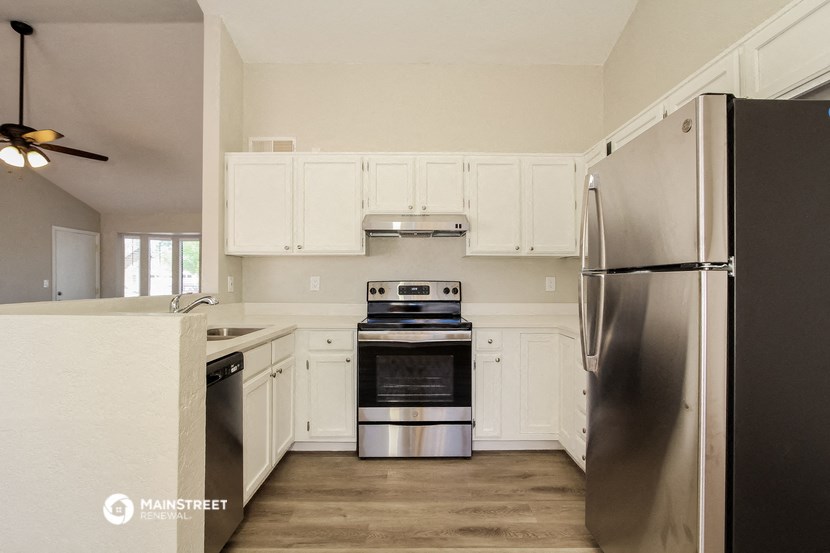 a kitchen with white cabinets and stainless steel appliances