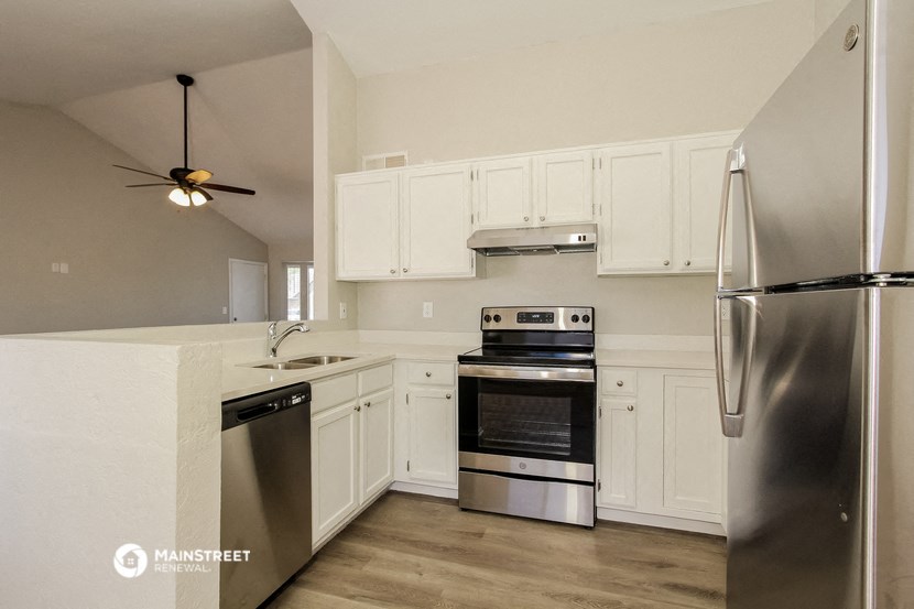a kitchen with stainless steel appliances and white cabinets