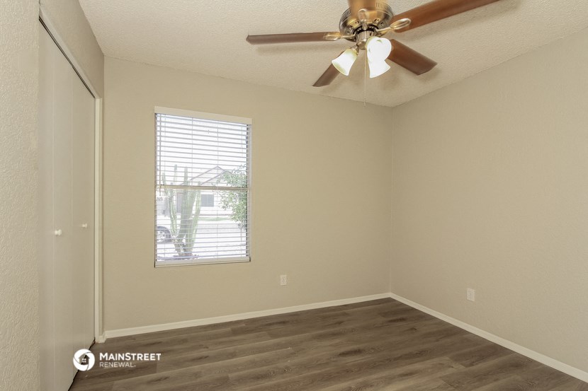 a bedroom with a ceiling fan and a window