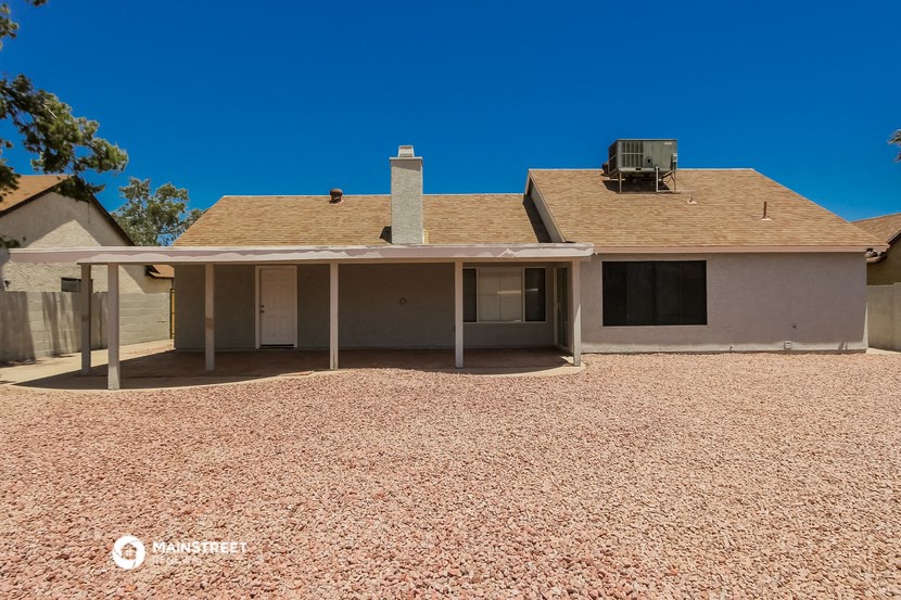 a house with a roof and a gravel yard
