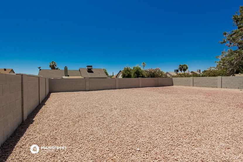 a gravel driveway with a house in the background