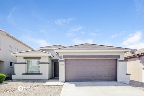 a white house with a garage door and a blue sky